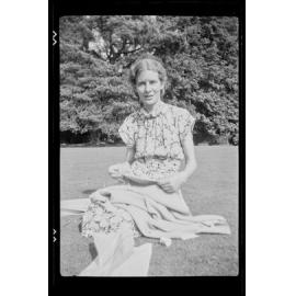 Woman sitting on grass with sewing