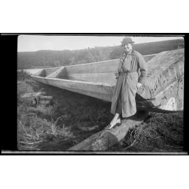 Unidentified woman next to carved-out log