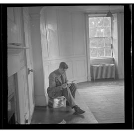 Man reading a book in an unfurnished room [Roger Cox]