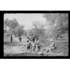 Three people and laden mules [?] on rural road