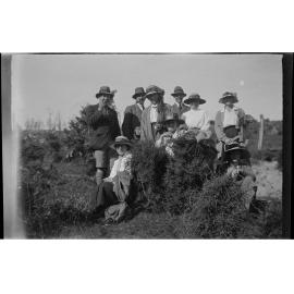 Nine people among shrubs on an outdoor trip