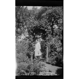 Girl standing beneath a garden arch