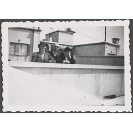 Unknown man and two women on a rooftop