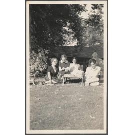 Group sitting on a lawn, including Charles Brasch