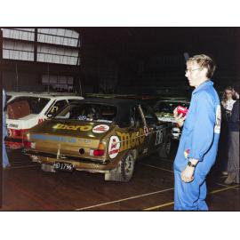 Man standing near Hillman Avenger rally car sponsored by Cadbury Moro