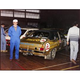 Man standing next to Hillman Avenger rally car sponsored by Cadbury Moro