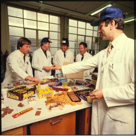 Five Cadbury staff in lab coats with arrangement of products