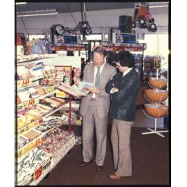 Two men standing next to a Cadbury display stand