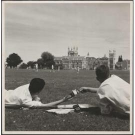 Two boys with Cadbury Dairy Milk chocolate on Otago Boys' High School playing field