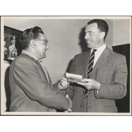Bob Dennison receiving a gold watch from Ted Barringer