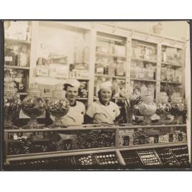 Two women wearing Cadbury uniforms, behind a shop counter