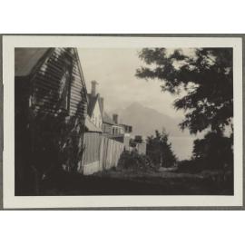 Fence line and house with mountains in the background