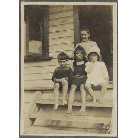 Charles and Lesley Brasch and two unidentified children sitting on steps