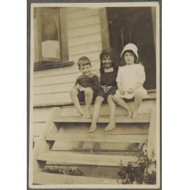 Lesley Brasch and two unidentified children sitting on steps