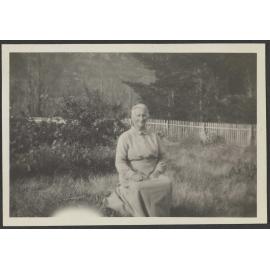 Unidentified woman sitting in grass field