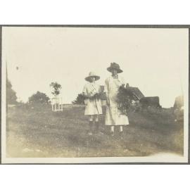 Two unidentified women in paddock with cows