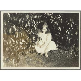 [Elespie Forsyth] sitting by shrubs