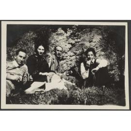 Lesley Brasch and three unidentified people next to rock cliff