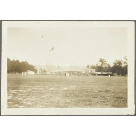 Cricket game looking towards [club rooms] flying Union Jack
