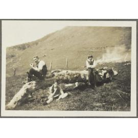 Lesley Brasch and two uidentified children sitting around large log
