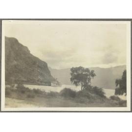 Ship docked at wharf among mountains