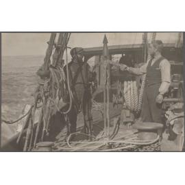 Two crew members holding a harpoon