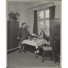 Two Plunket nurses posing with publication titled 'Woman and Child'