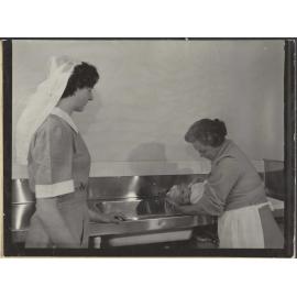 Nurse and mother [?] bathing baby