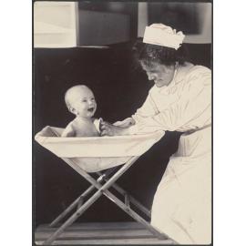 Nurse bathing a baby