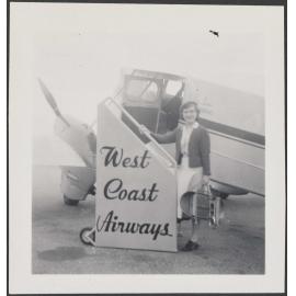Woman standing in front of a West Coast Airways plane