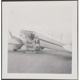 Woman standing in front of a West Coast Airways plane