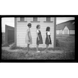 Three girls standing side on