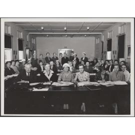 Group of people sitting at desks in a meeting room