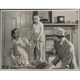 A nurse 'Weighing the Pre School child in the home'