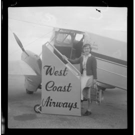 Woman standing in front of a West Coast Airways plane