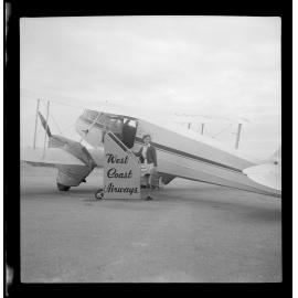 Woman standing in front of a West Coast Airways plane