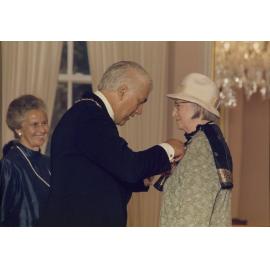 Sir Paul Reeves presenting Dallas with her CBE medal, Lady Reeves in background
