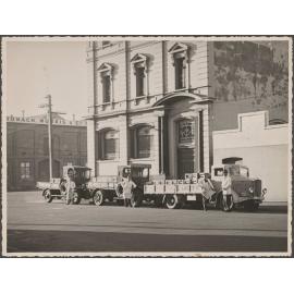Four people and three delivery trucks outside Thomsons premises