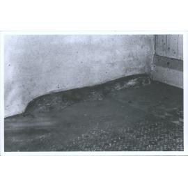 Stone (not blue stone or other hard rock) left in place with brick party wall built over floor boards contoured to shape